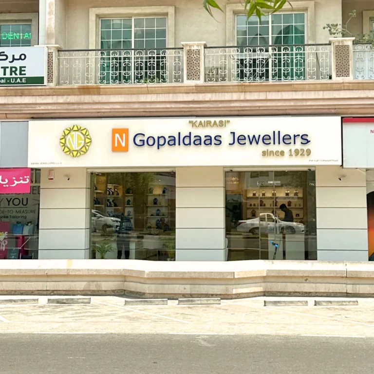 Storefront of a jewelry shop with large glass windows and a decorative white railing above the entrance, sign reads 'Gopaldaas Jewellers'.